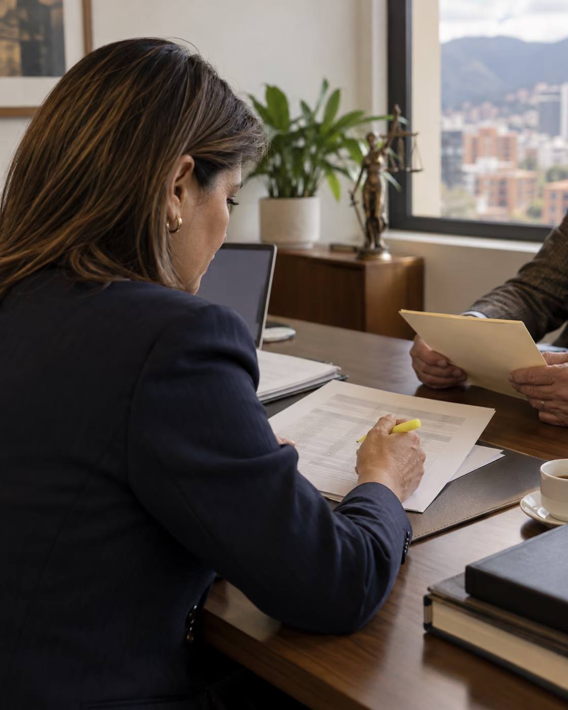 Abogada revisa una historia laboral con un resaltador junto a su cliente